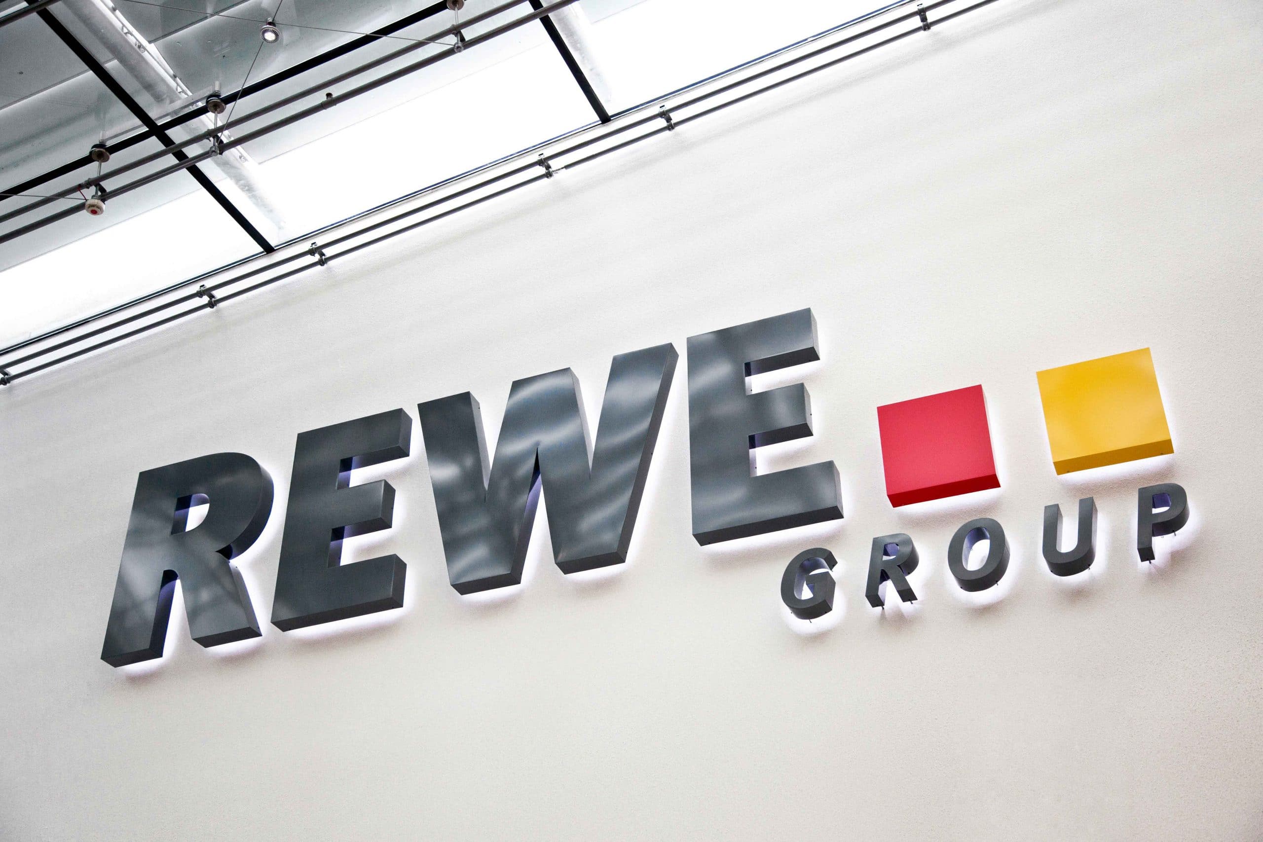 Das Logo der REWE Group in 3D und beleuchtet