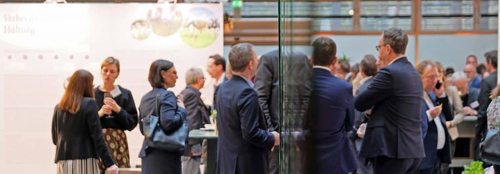 Ein Konferenzsaal gefüllt mit Menschen, die sich im Gespräch befinden