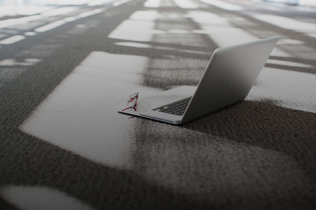 Ein Laptop steht auf dem Boden. Eine Brille liegt auf der Tastatur. Ein Symbolbild für unserem Creditor Relations Bereich