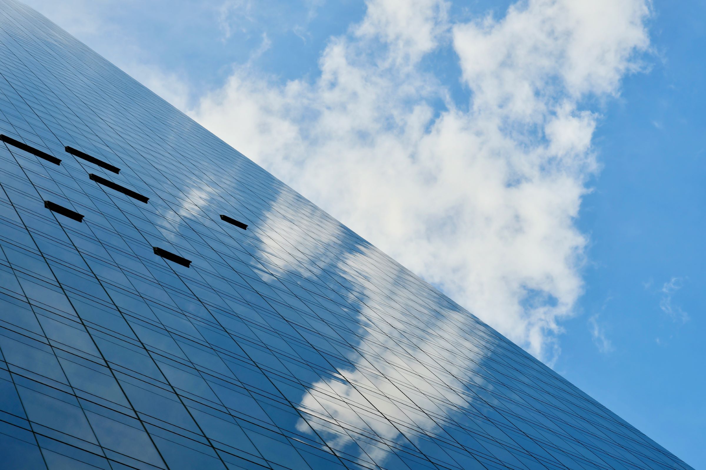 Fenster eines Gebäudes reflektieren wolkigen Himmel