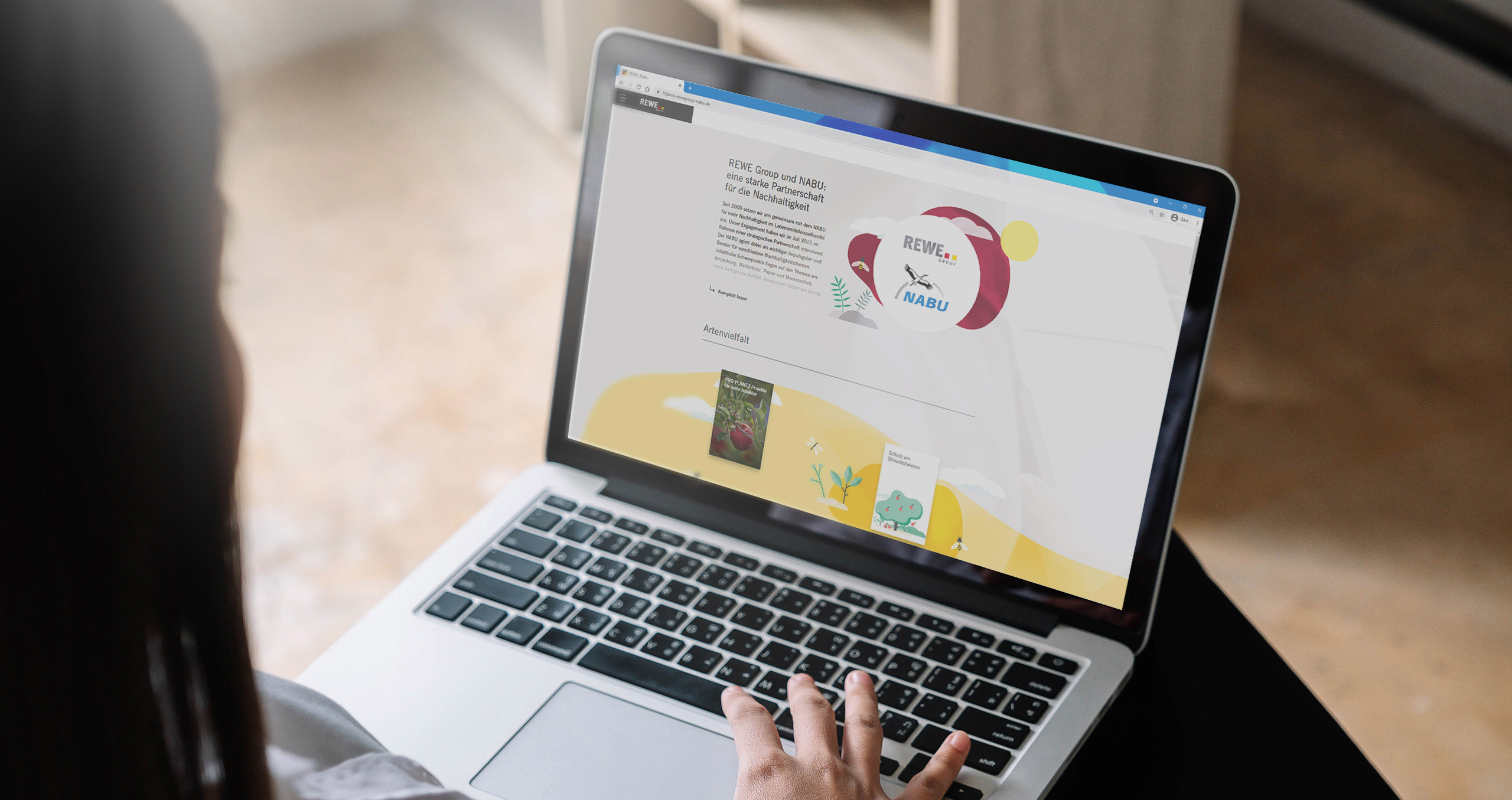 Ein Laptop, auf dem die Startseite der REWE Group & NABU Website zu sehen ist.