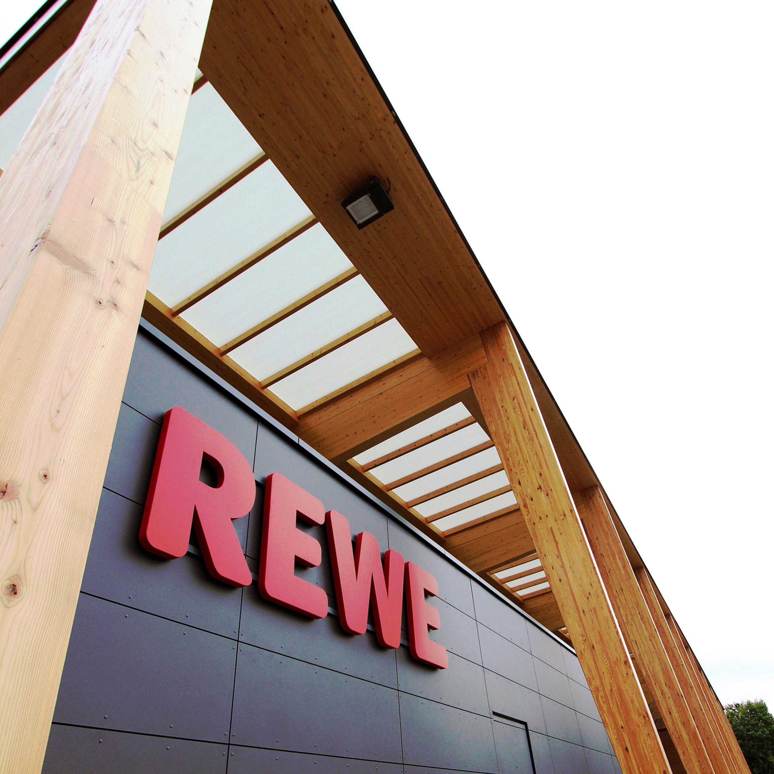 Das REWE Logo an einer Markt-Außenansicht
