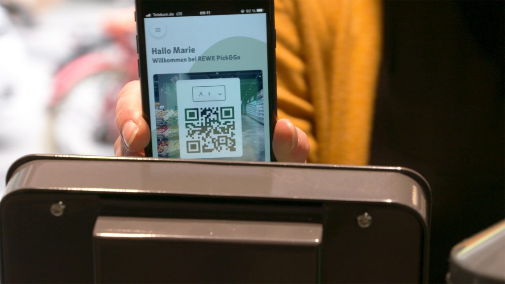 Smartphone wird an der Kasse mit Hilfe der Pick&Go App gescannt