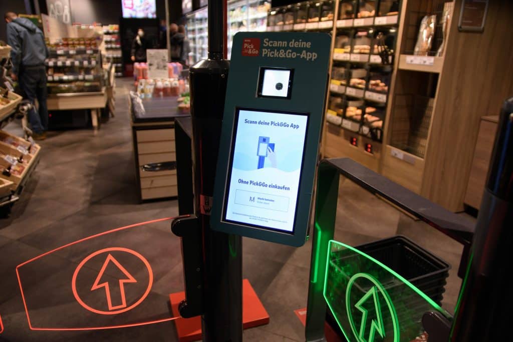 Der Eingang eines REWE Marktes, an dem die REWE Pick&Go-App eingescannt werden kann, um den kassenlosen Einkauf zu beginnen.