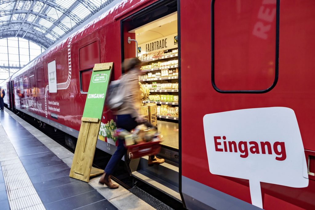 Eingang des Supermarktzugs mit einsteigender Kund:in