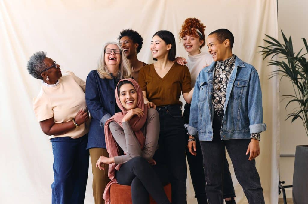 Eine Gruppe unterschiedlicher Frauen lachen miteinander.