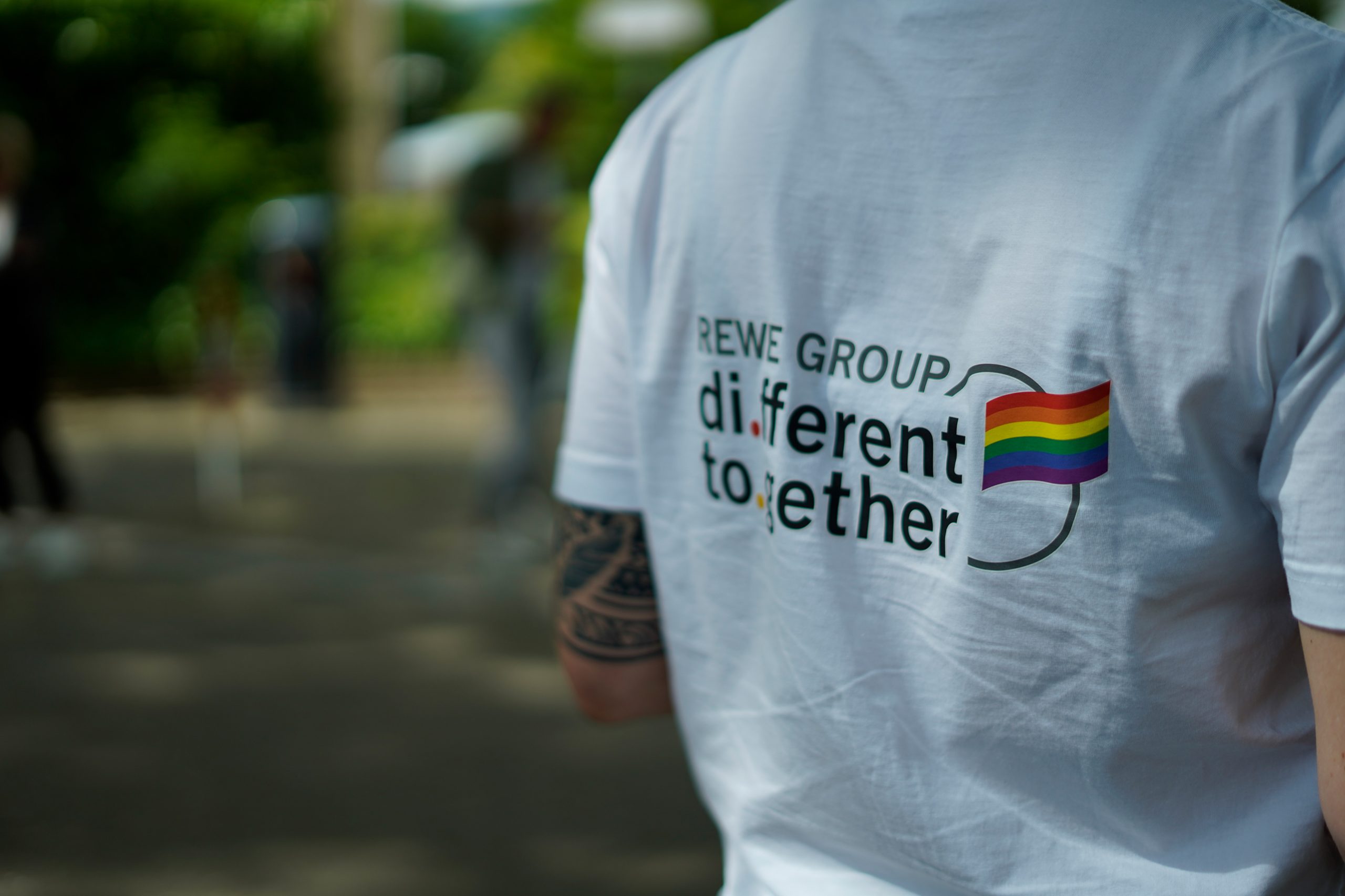 Rückansicht eines T-Shirts mit dem Schriftzug REWE GROUP di.ferent to.gether.
