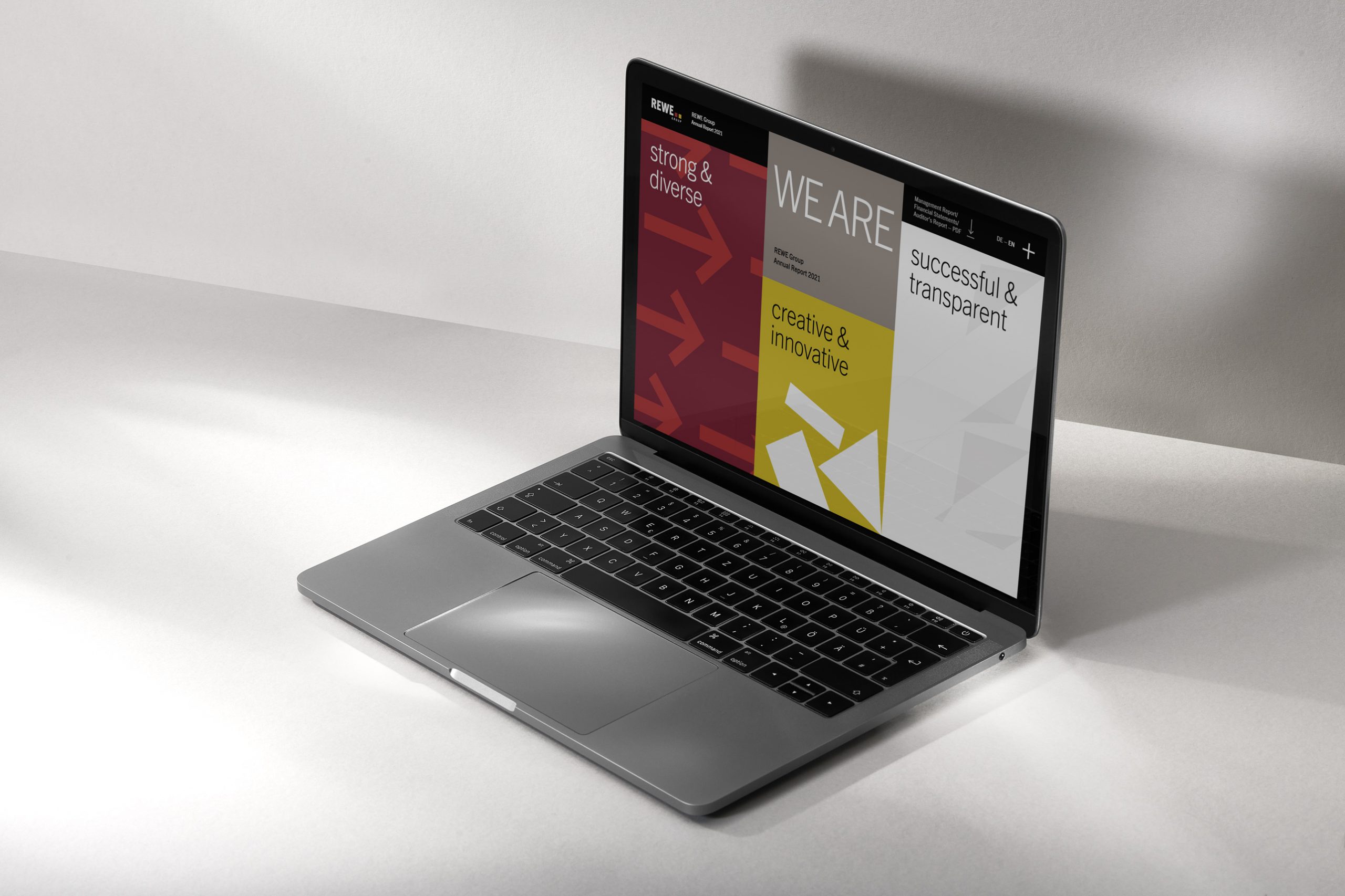 Ein aufgeklappter Laptop vor einem monotonen Hintergrund. Darauf ist eine Power Point geöffnet. Es ist der Geschäftsbericht Mockup von 2022
