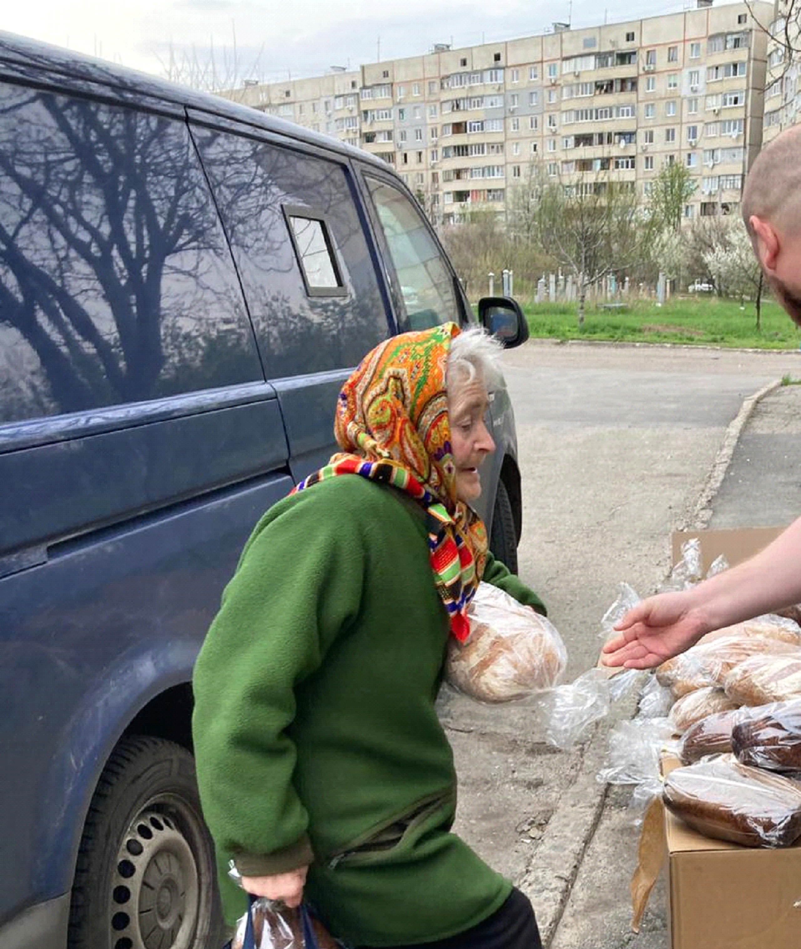 Eine ältere Ukrainerin nimmt eine Lebensmittelspende entgegen.