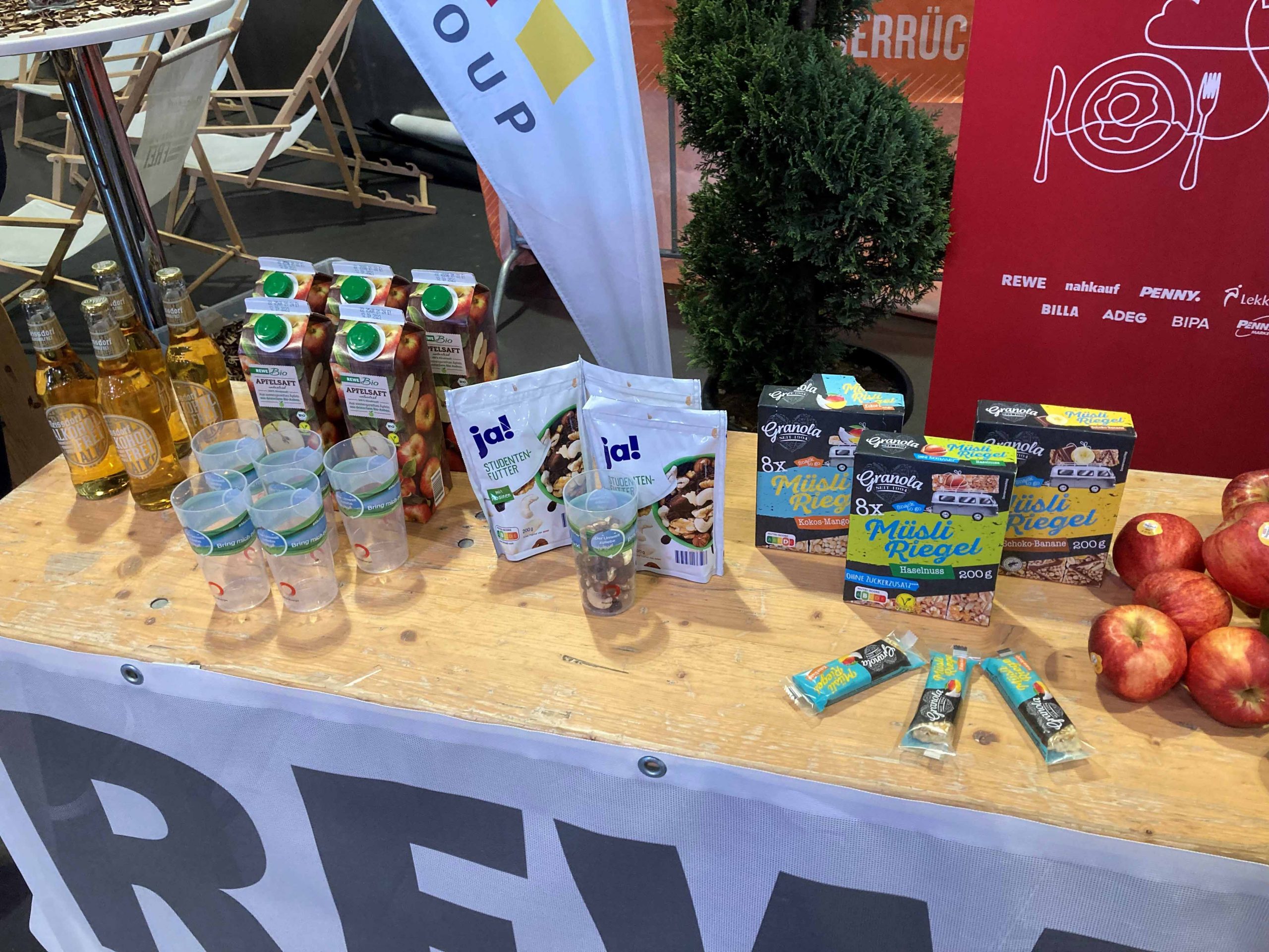 Ein Verpflegungsstand der REWE Group für den Köln Marathon, auf dem die gesponserten Produkte zu sehen sind