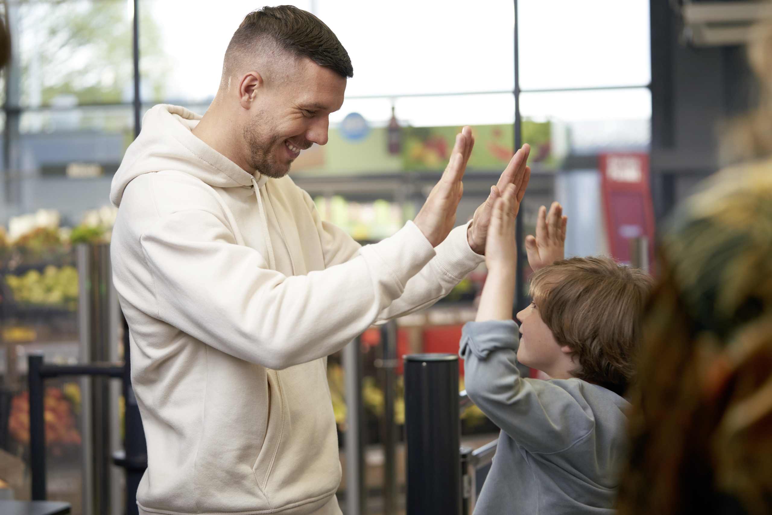 Lukas Podolski gibt einem Jungen High Five