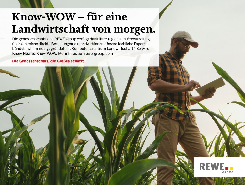 Person mit digitalem Pad in der Hand, welche in einem Feld mit Pflanzen steht.