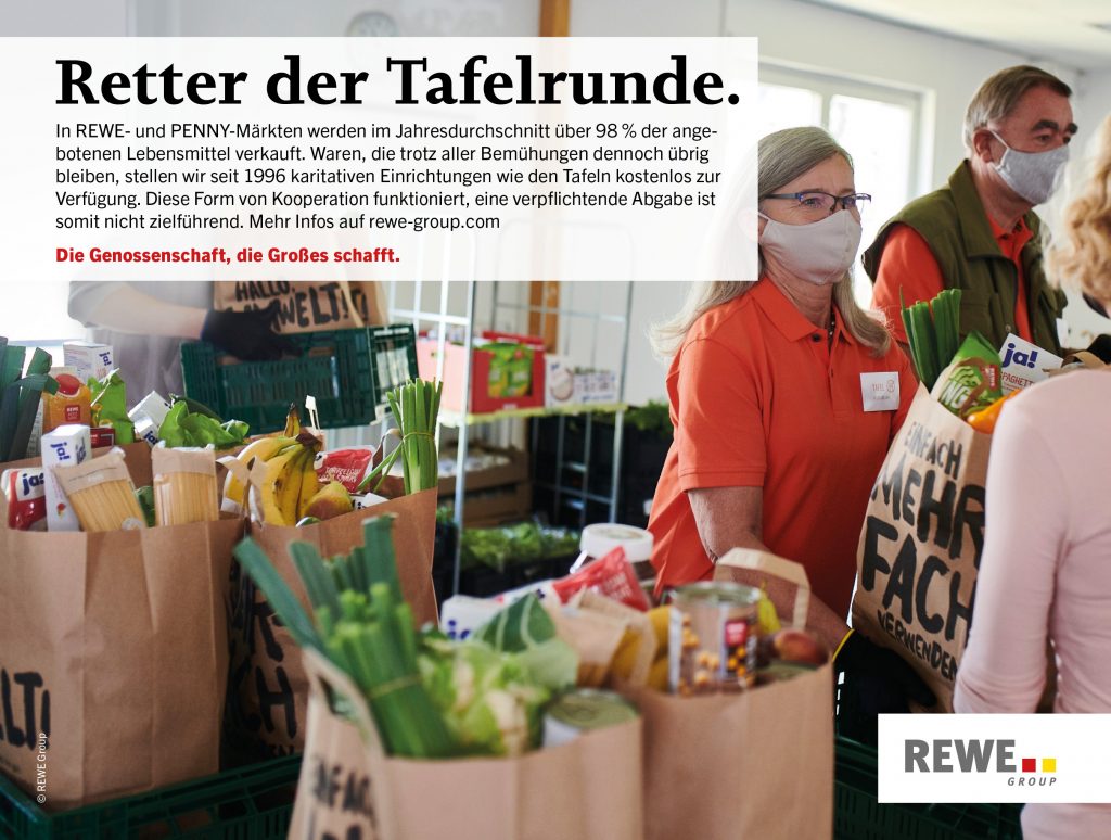 Mitarbeiterin der Tafel verteilt REWE Tafeltüten