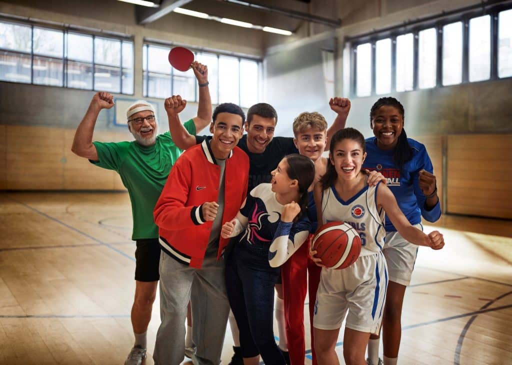 Gruppe von Menschen in einer Turnhalle mit dem Fussballspieler Jamal Musiala