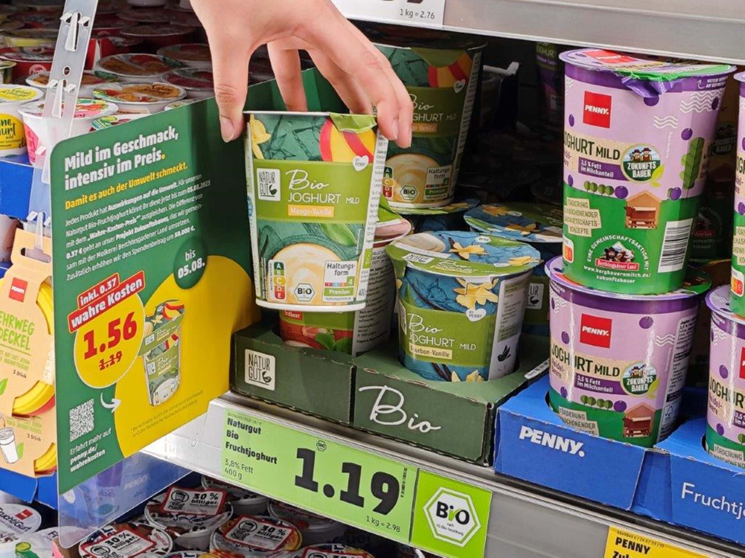 A hand holding a container of Yoghurt