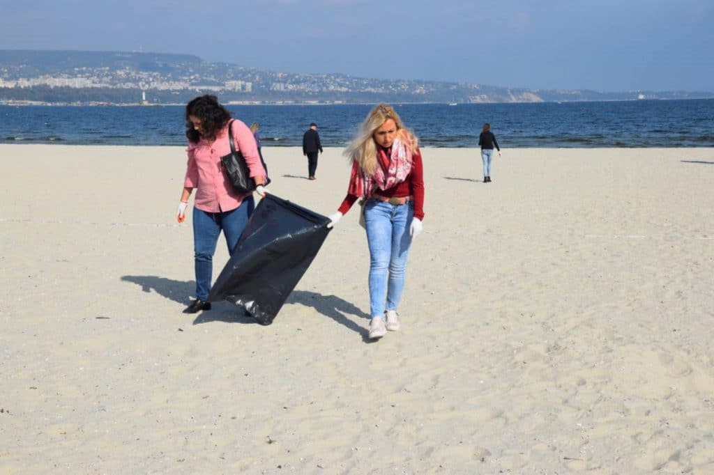 Frauen mit Plastiktüte am Strand