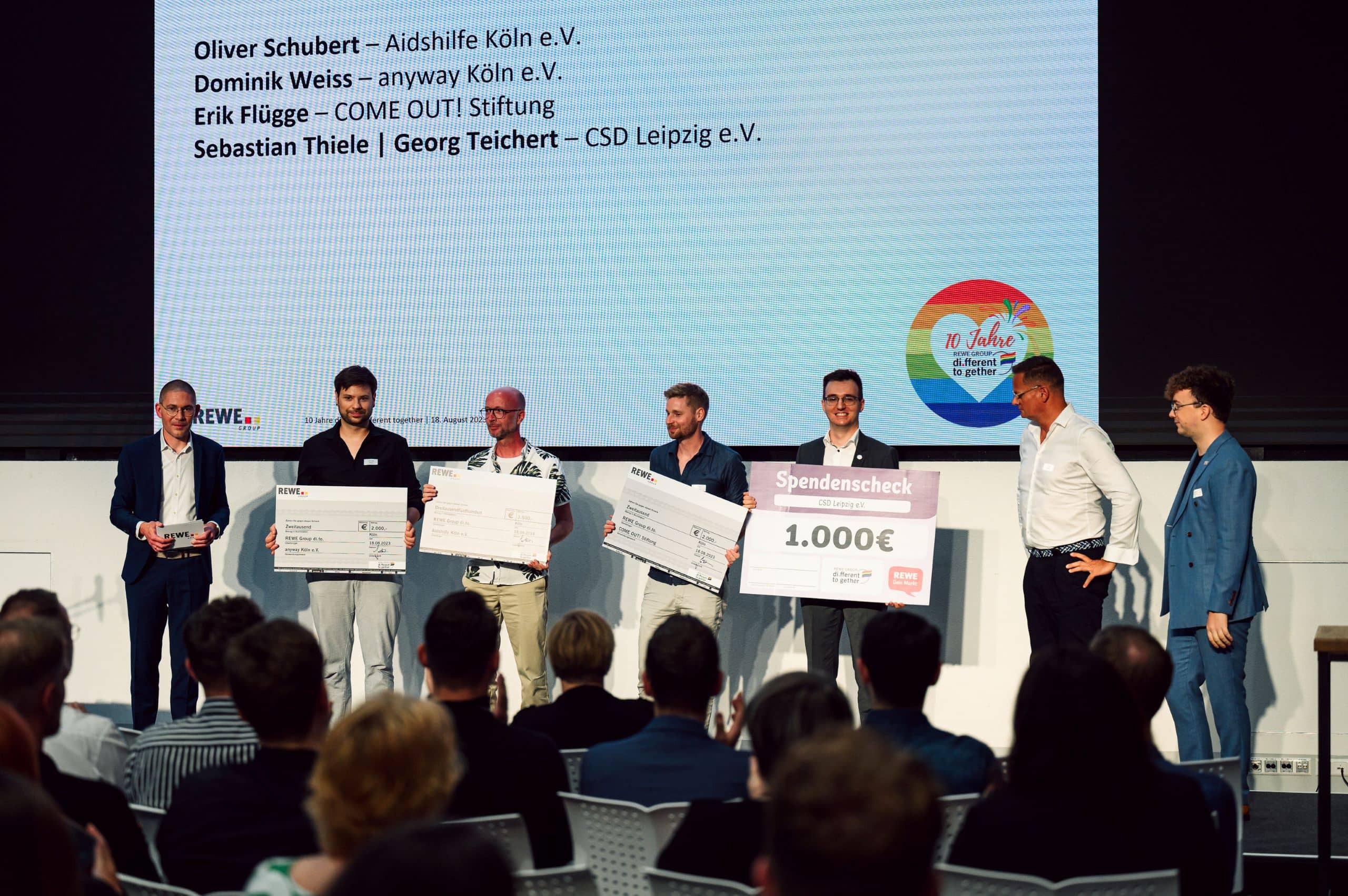 Menschen auf der Bühne zur Spendenübergabe.