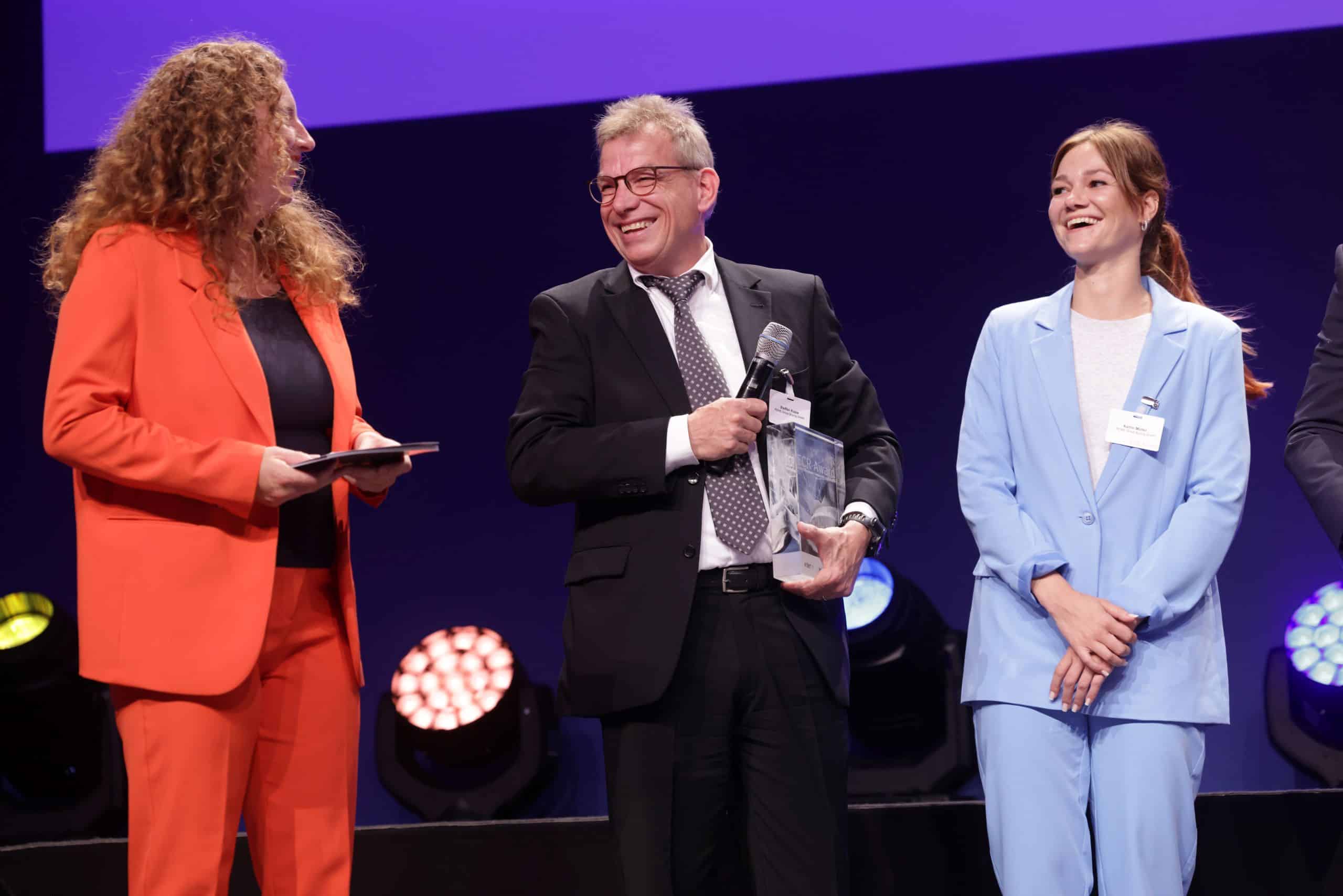 Steffen Kujus und Katrin Müller (beide REWE Group Buying) nehmen den Preis von Moderatorin Regina Haas-Hamannt entgegen.