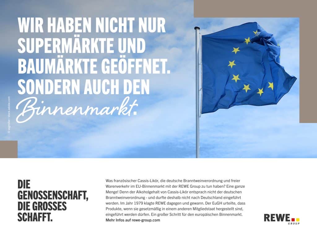 Flaggen der Europäischen Union vor blauem Himmel und dem Schriftzug 