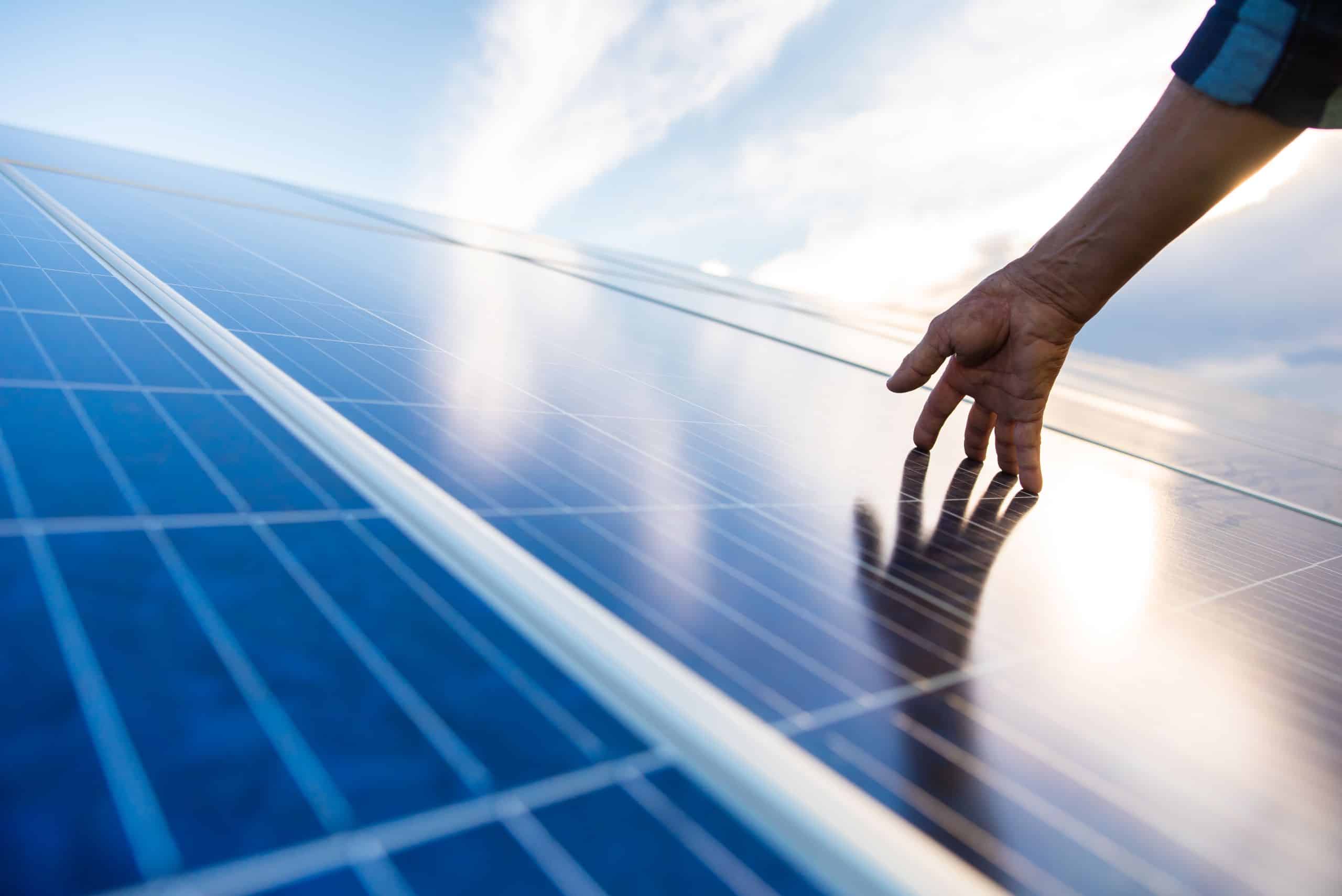 A hand on a module of a photovoltaic system