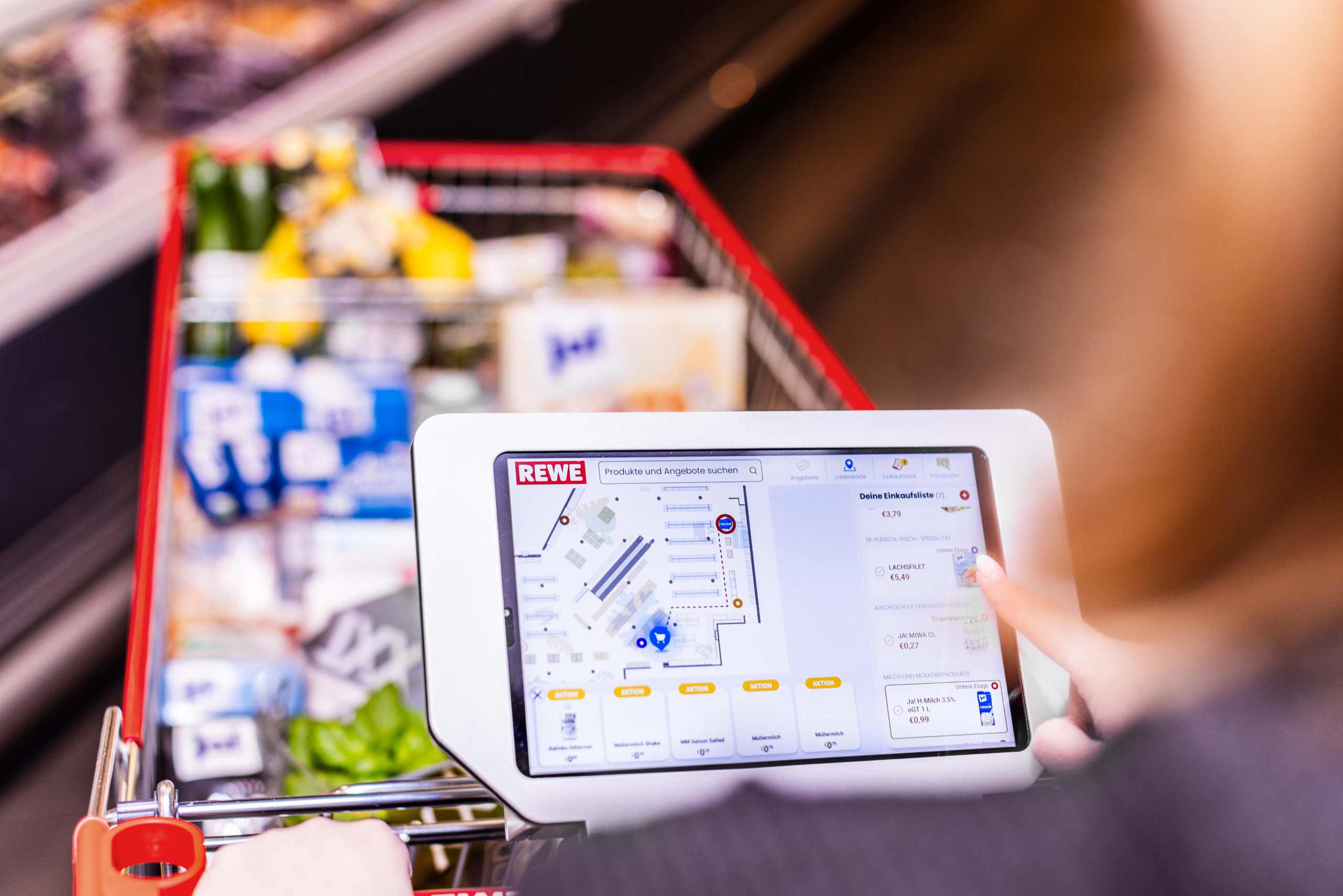 Einkaufswagen im REWE Markt mit integriertem Tablett.