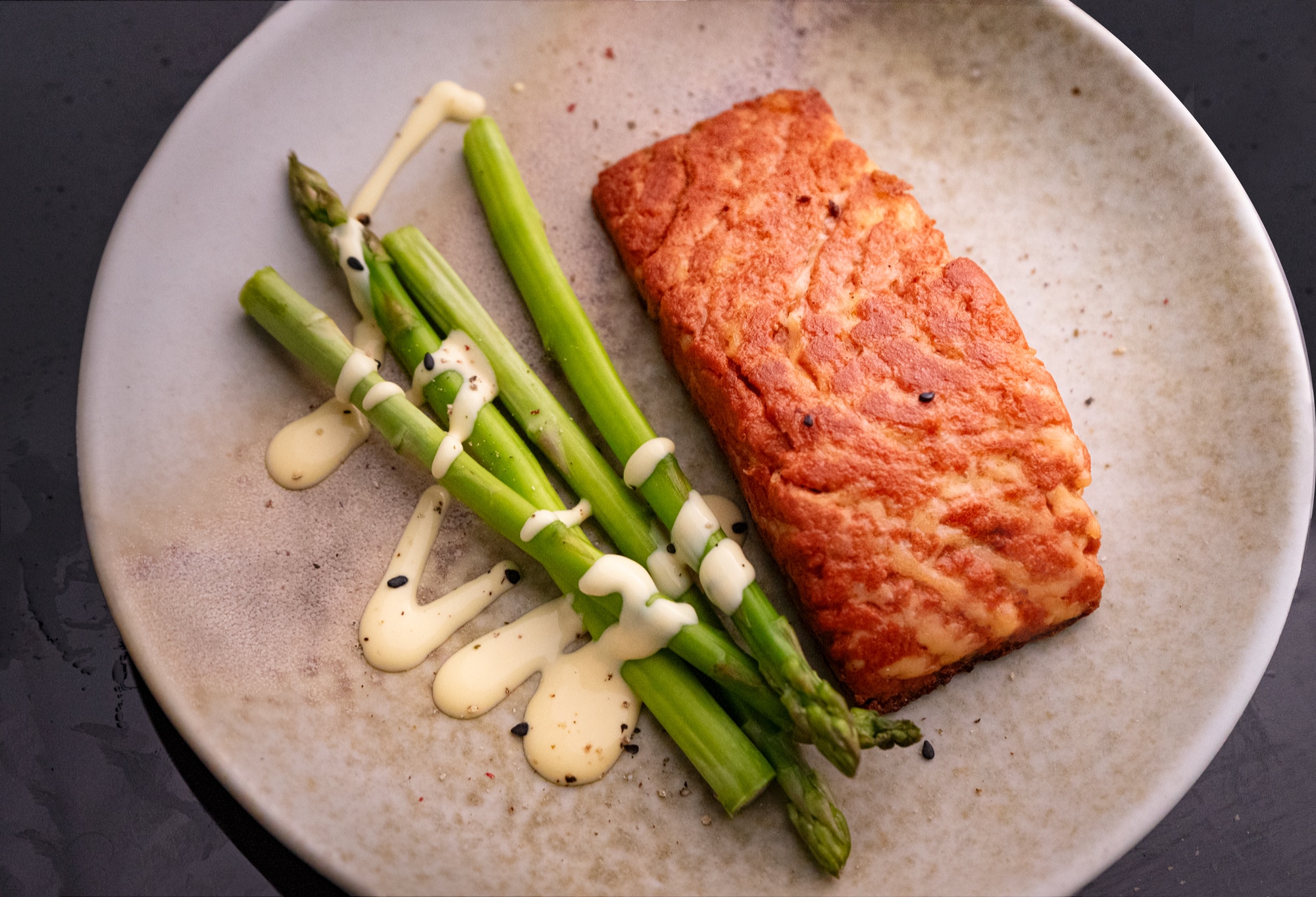 Gedrucktest Lachsfilet aus Pilzen auf einem Teller mit Spargel