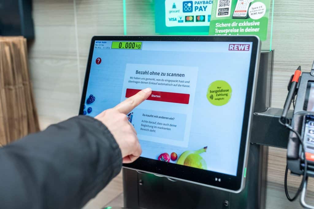 Hand an Pick and Go Terminal auf dem "Bezahl ohne zu scannen" steht
