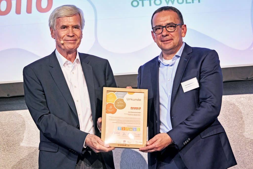 Dominique Rotondi, Geschäftsführer Einkauf und Logistik und verantwortlich für das Nachhaltigkeitsmanagement bei toom bekommt die Urkunde zur Allianz der Pioniere überreicht.
