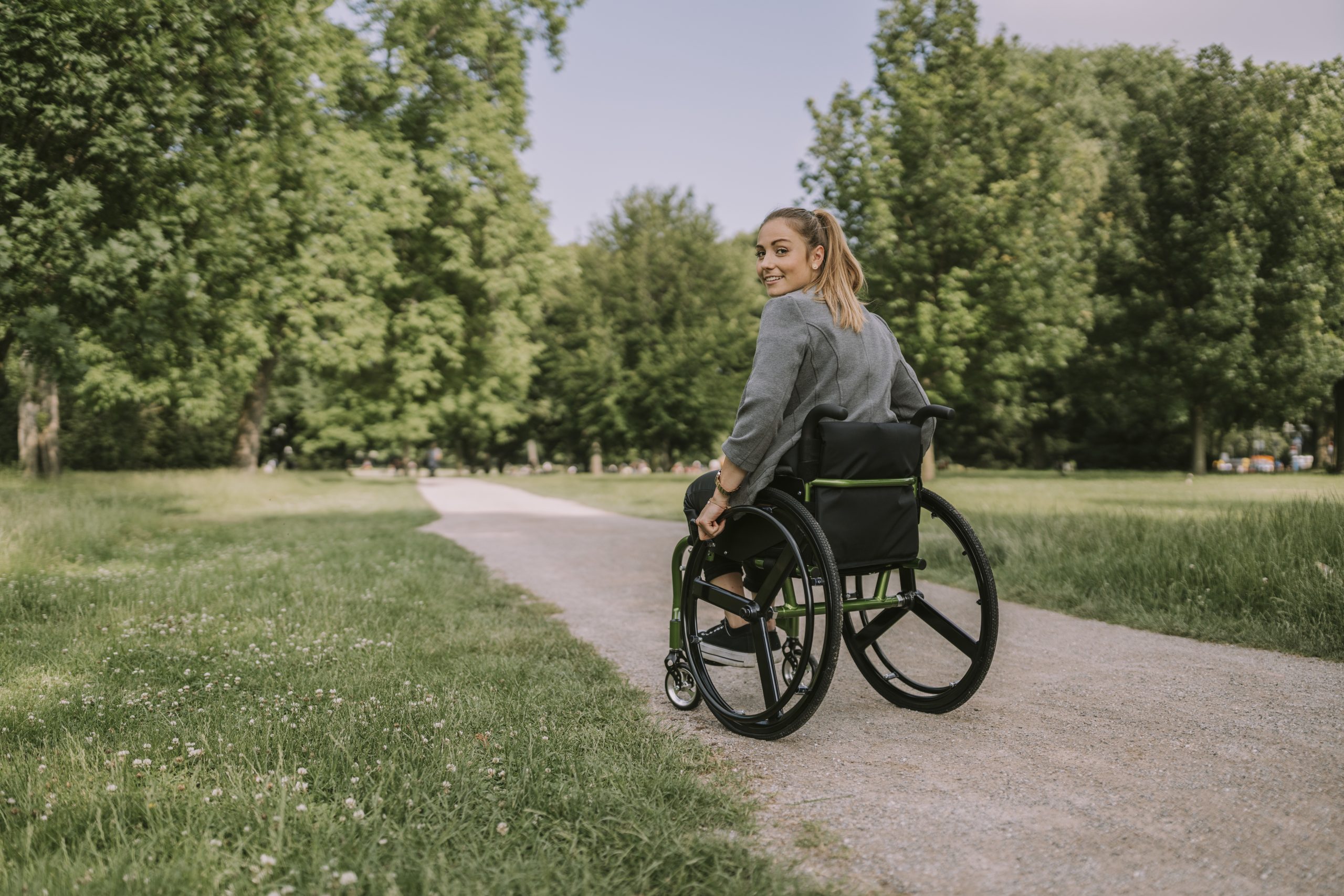 Young woman sitting in wheelchair at park