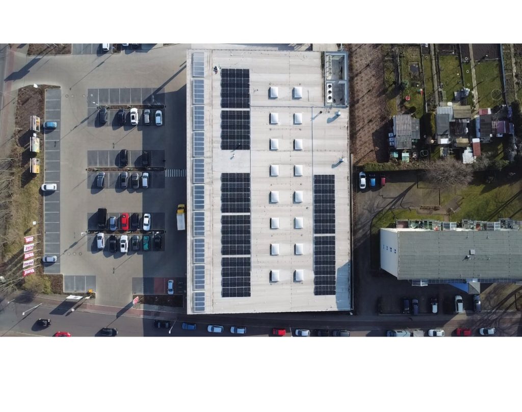 Luftaufnahme eines REWE-Marktes in Magdeburg mit Photovoltaik Anlage auf dem Dach.