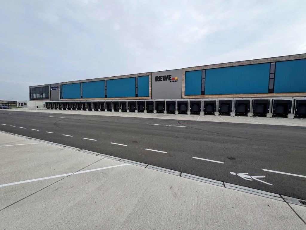 Außenansicht des REWE Group Solarlagers in Voerde mit dem Logo der REWE Group.