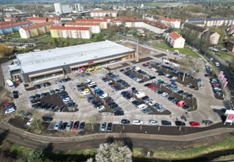 Luftaufnahme eines REWE Marktes mit Parkplatz