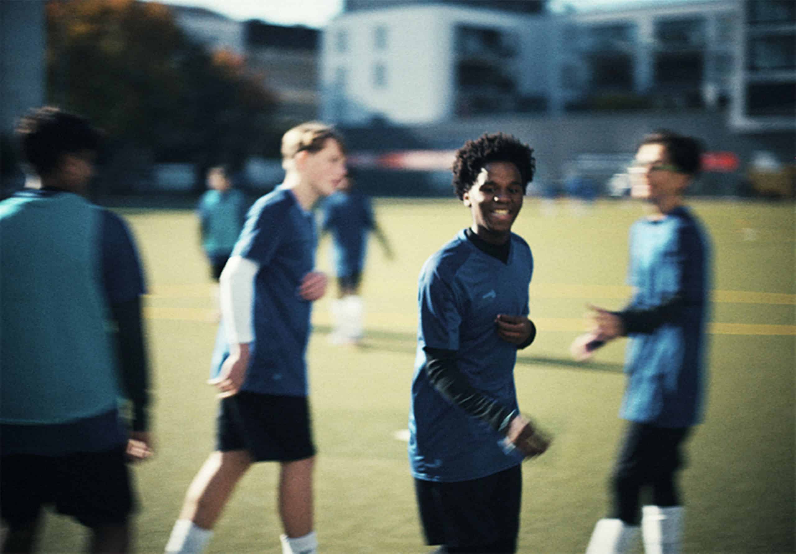 Jugendliche in Trikots auf einem Fußballfeld.