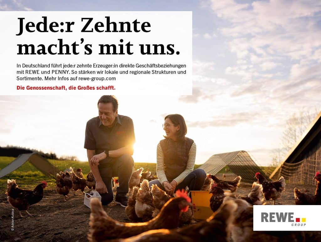 Zwei Landwirt:innen kümmern sich lachend um Hühner auf einem Bauernhof.