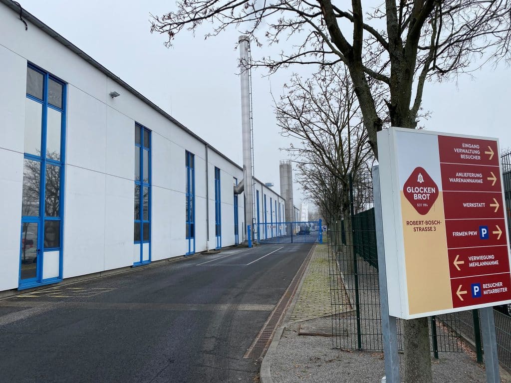 Außenansicht einer Industriehalle neben einem Wegweiser der Glockenbrot Bäckerei