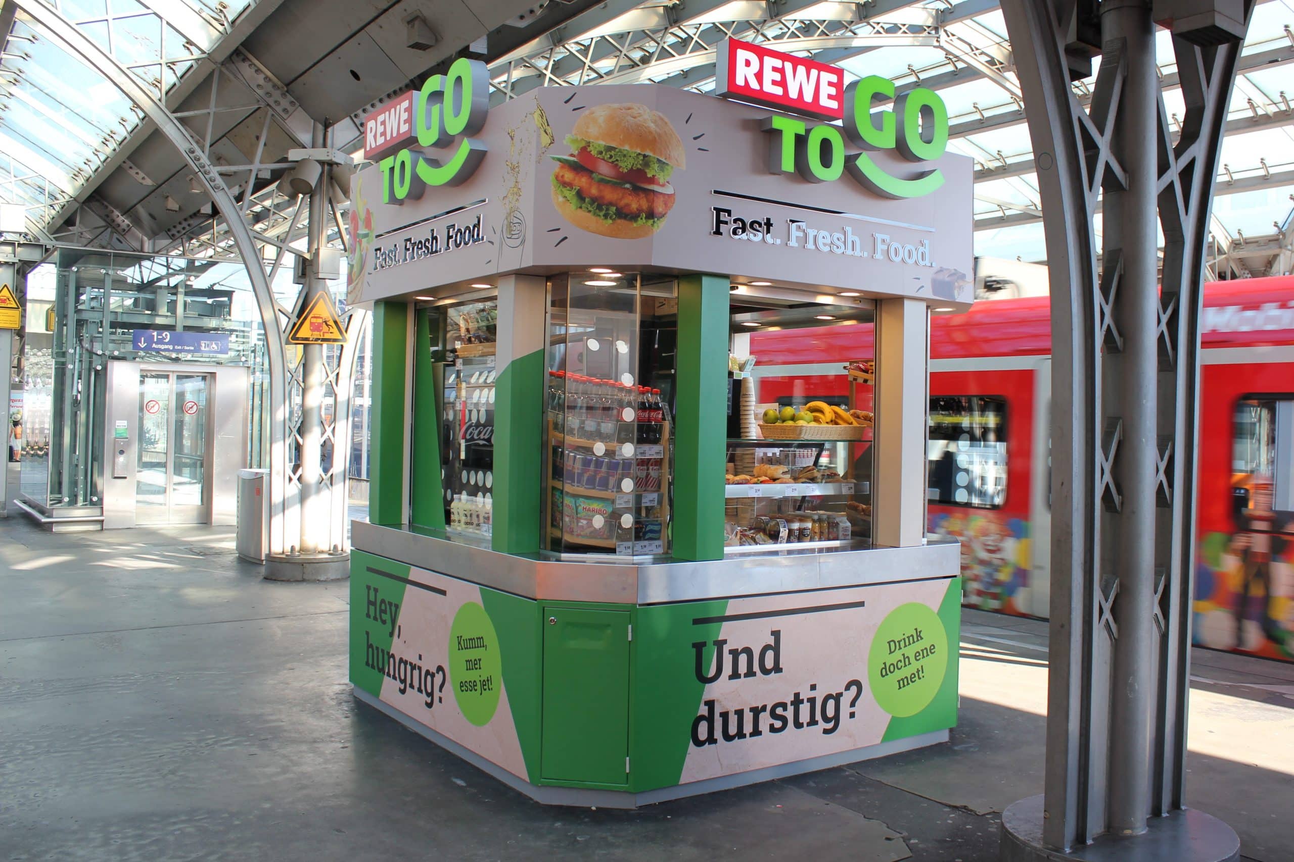 Außenansicht der REWE To Go Gleiskiosk am Kölner Hauptbahnhof.
