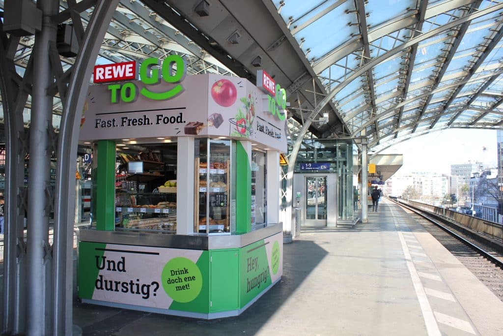 Außenansicht der REWE To Go Gleiskiosk am Kölner Hauptbahnhof.