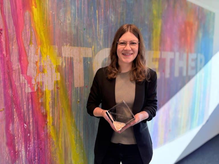 Porträt von Charlotte Ehl vor einer bunten Wans mit dem Schriftzug #Together