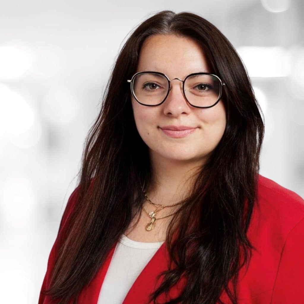 Portrait of Martina Weinhold. She smiles at the camera, the background is blurred.