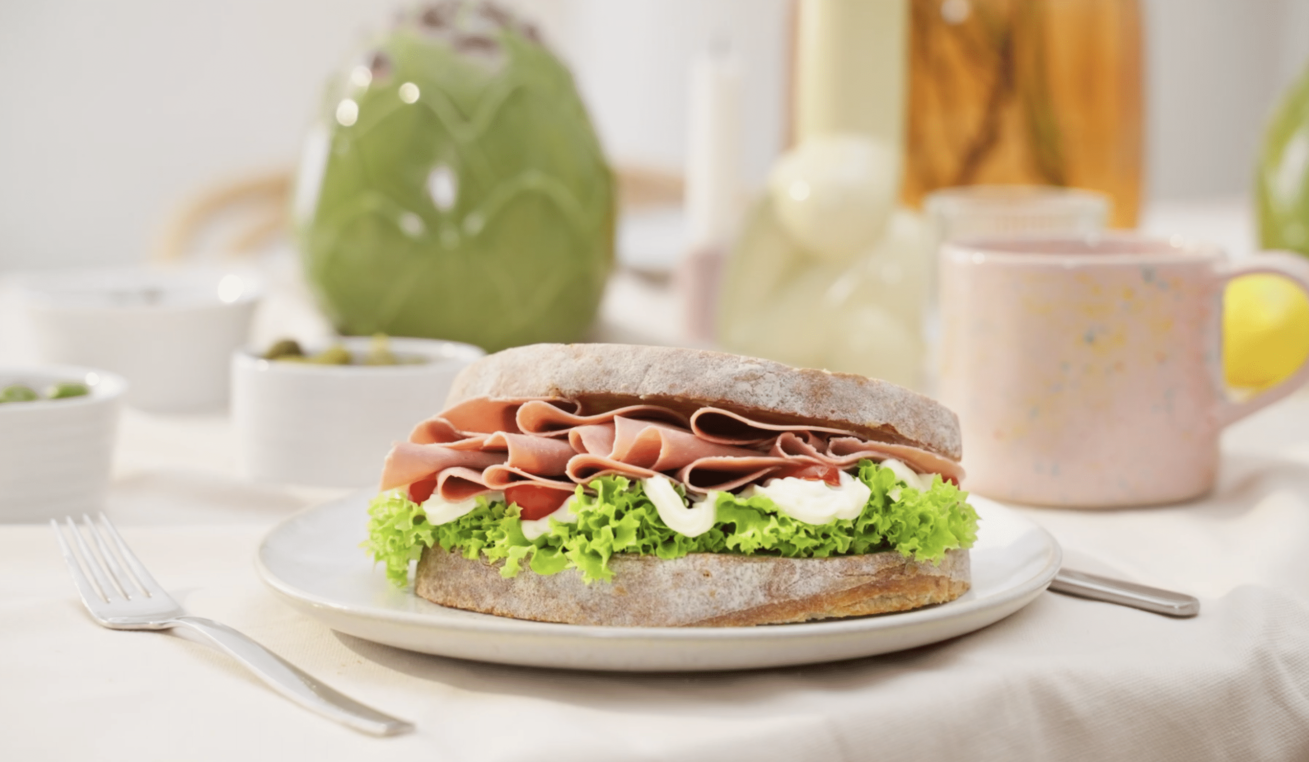 A sandwich with plant-based cooked ham from the LEKKA brand is on a plate.