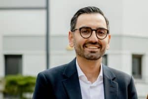 Porträt von Karim Fereidooni. Er lächelt in die Kamera.