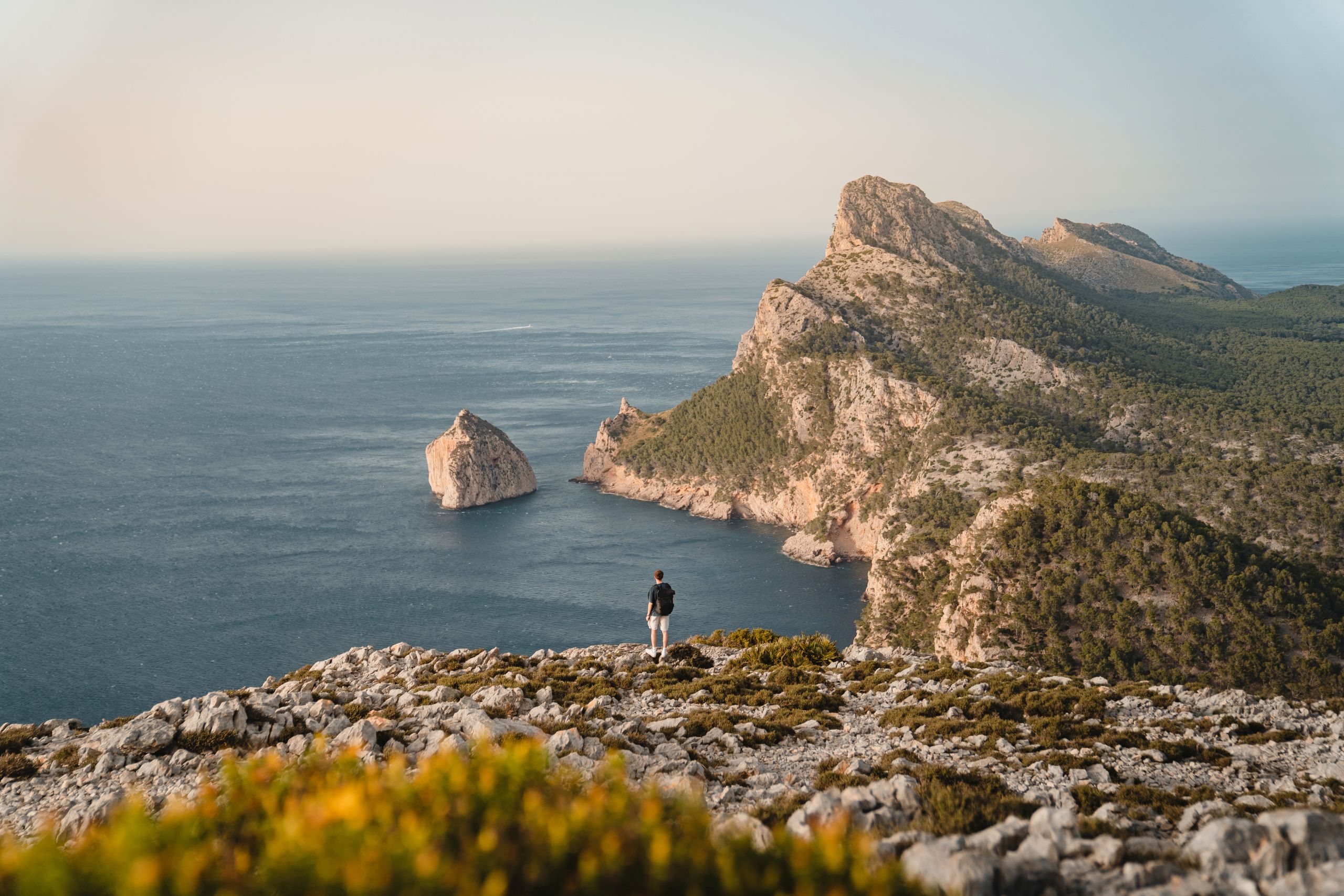Küste von Formentor auf Mallorca mit steilen Felsen, Meer und vorgelagertem Fels im Wasser.