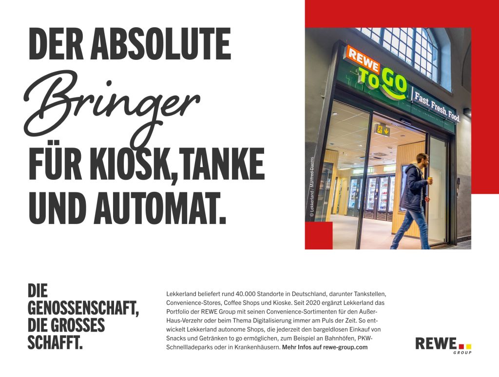 Ein beleuchteter REWE To Go‑Eingang mit Glastüren und Innenansicht eines Shops ist zu sehen, während eine Person mit Getränk daran vorbeigeht, daneben großer Text: 