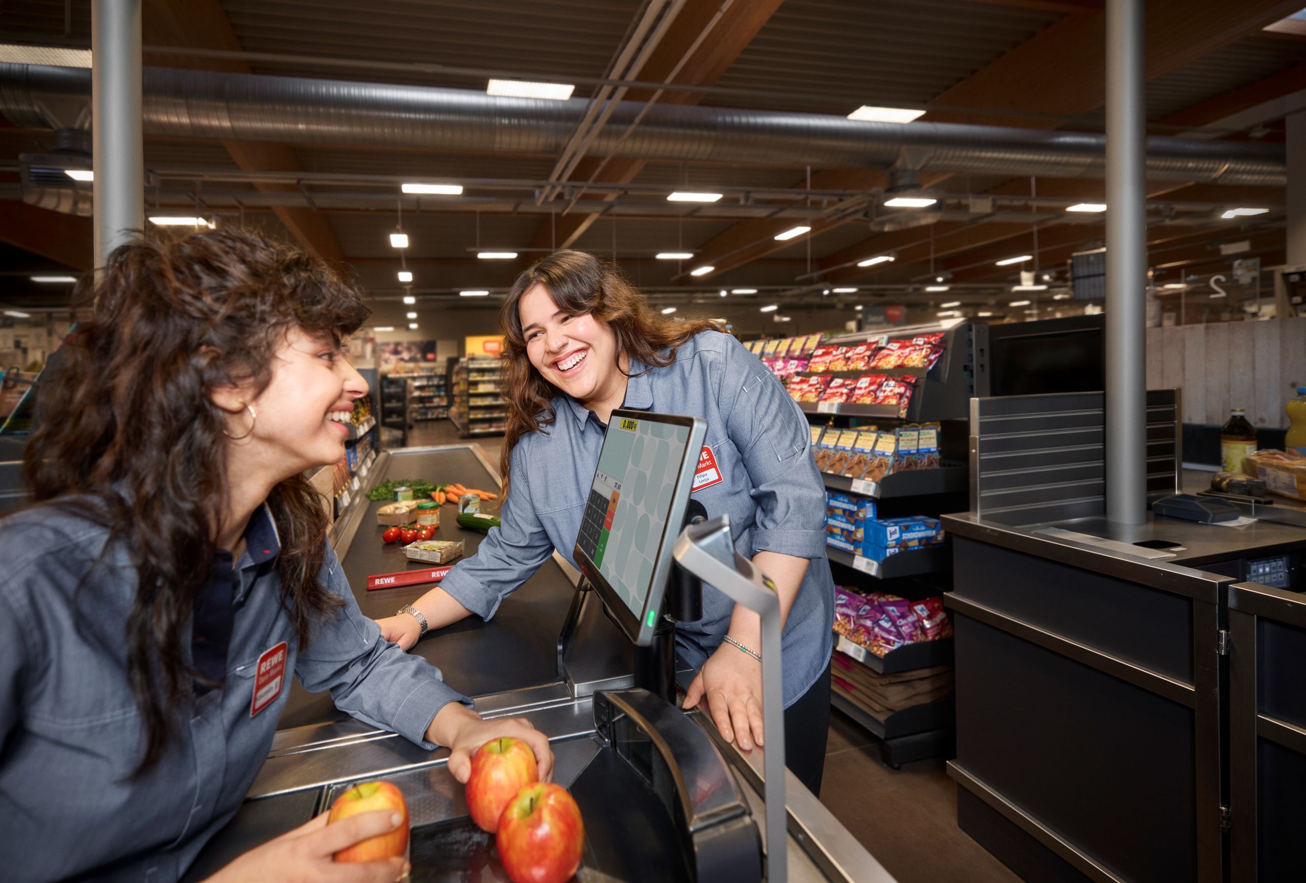 Zwei Frauen an der REWE Kasse