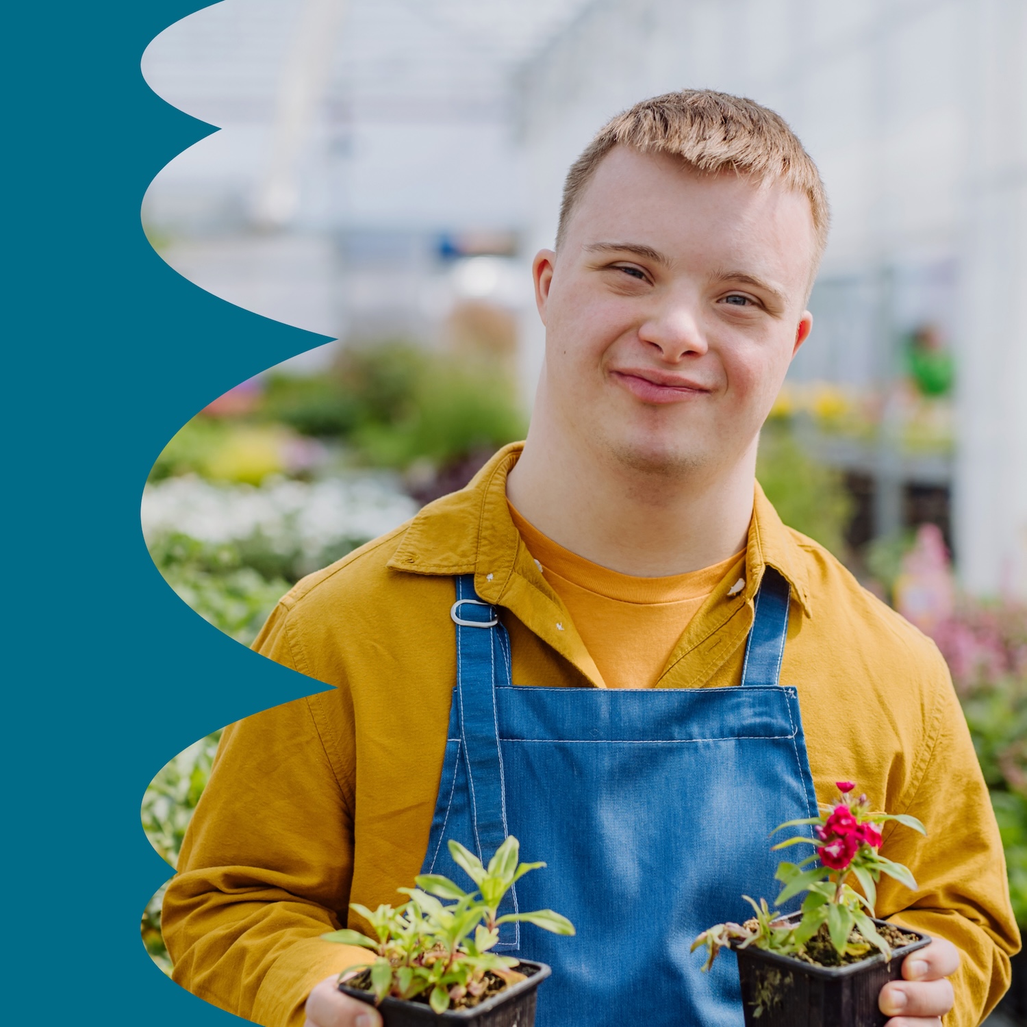 Junger Mitarbeiter mit Down-Syndrom kümmert sich um Blumen im Gartencenter.